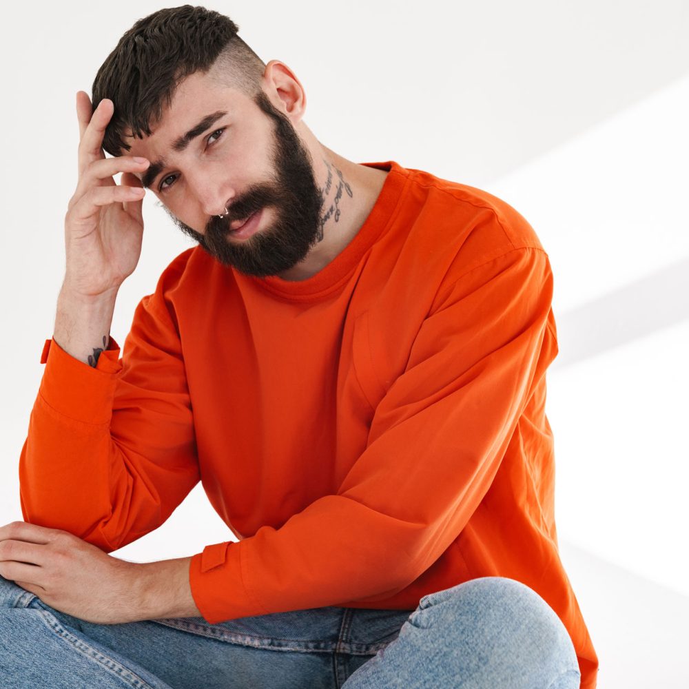 image-of-young-bearded-man-sitting-isolated-over-w-84SVLHT.jpg